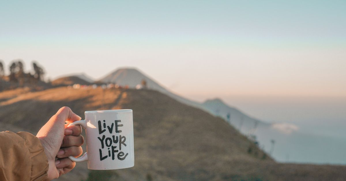 A person holding a coffee mug that says live your life while sharing their experience on how to overcome addiction.