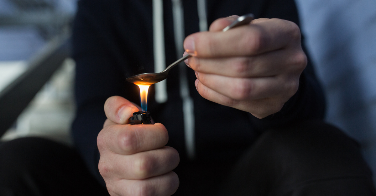 A man is experiencing crack withdrawal symptoms while holding a lighter.