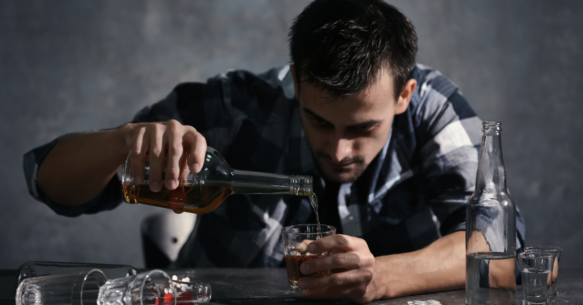 An man, who is suffering from alcoholism, is pouring alcohol.