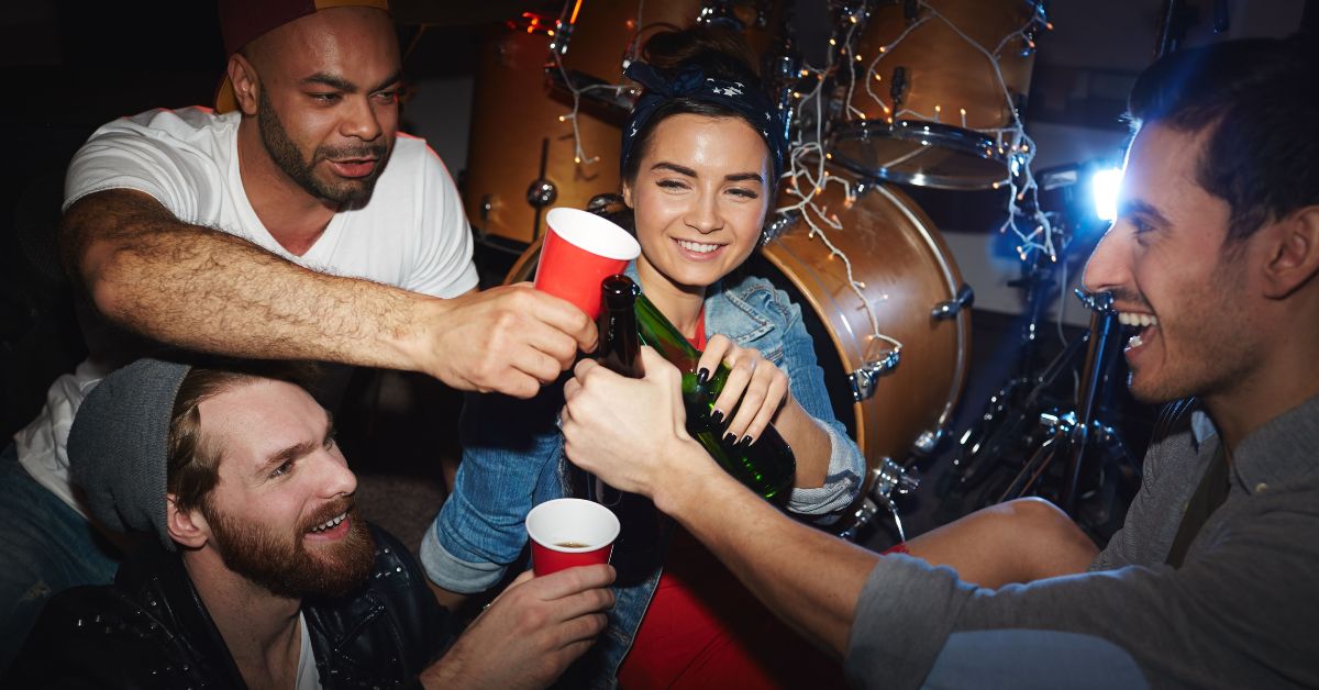 A group of friends toasting with beer at a party, and this is a high risk situation that can trigger relapse.