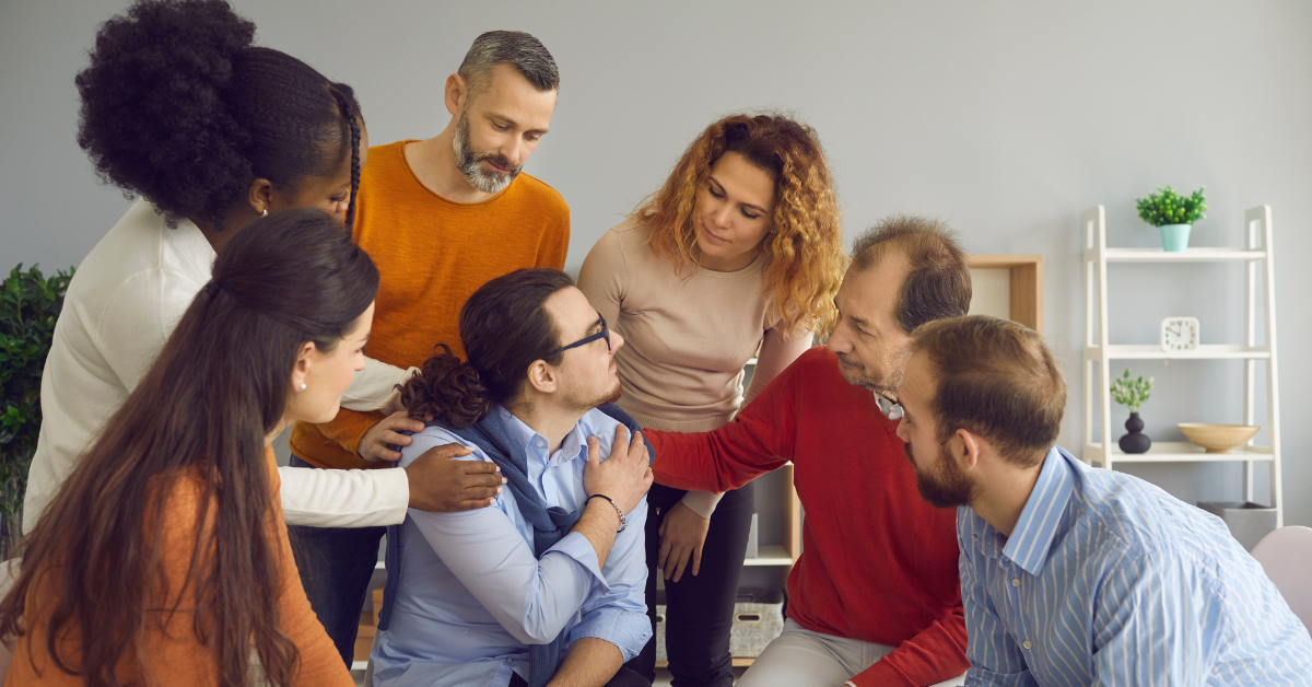 A resilient main who is in addiction recovery with this family sitting around a table.