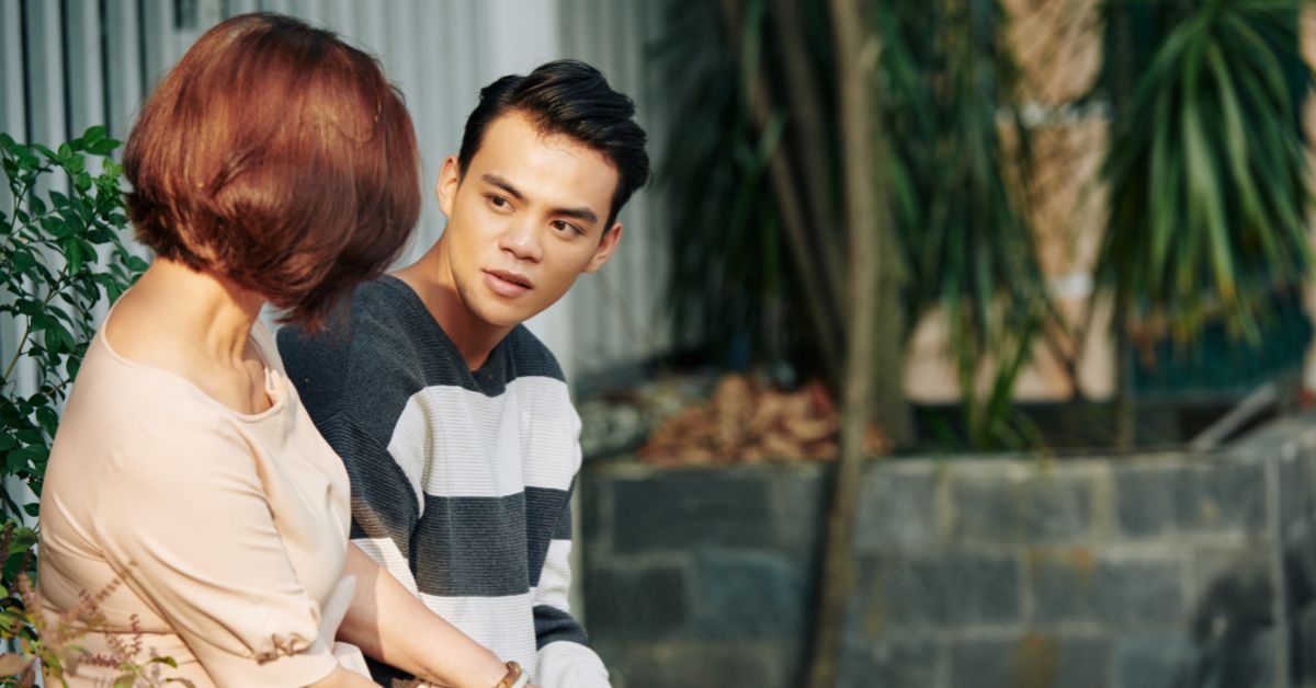A man and his mom sitting on a bench, talking about the stages of addiction recovery.