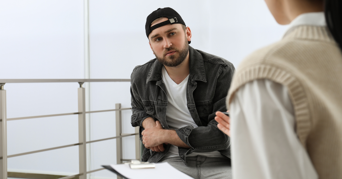 A man discusses relapse prevention strategies with a woman in an office.
