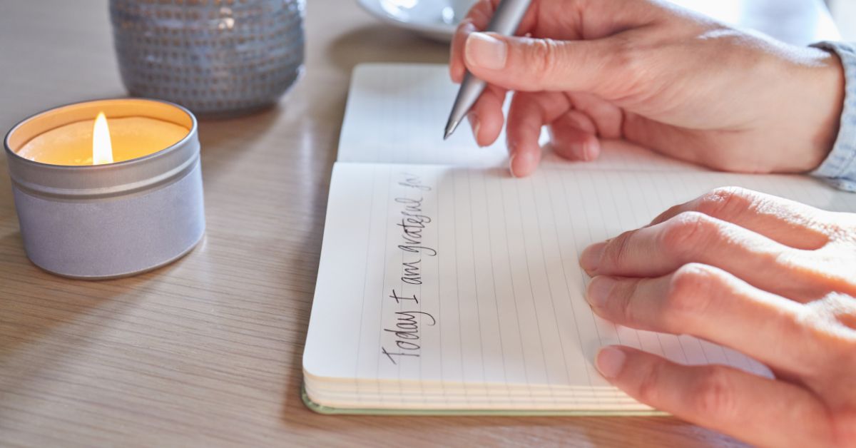 A person practicing self-reflection next to a candle.