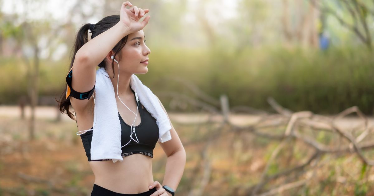 A young woman is practicing physical self-care while running with her earphones.