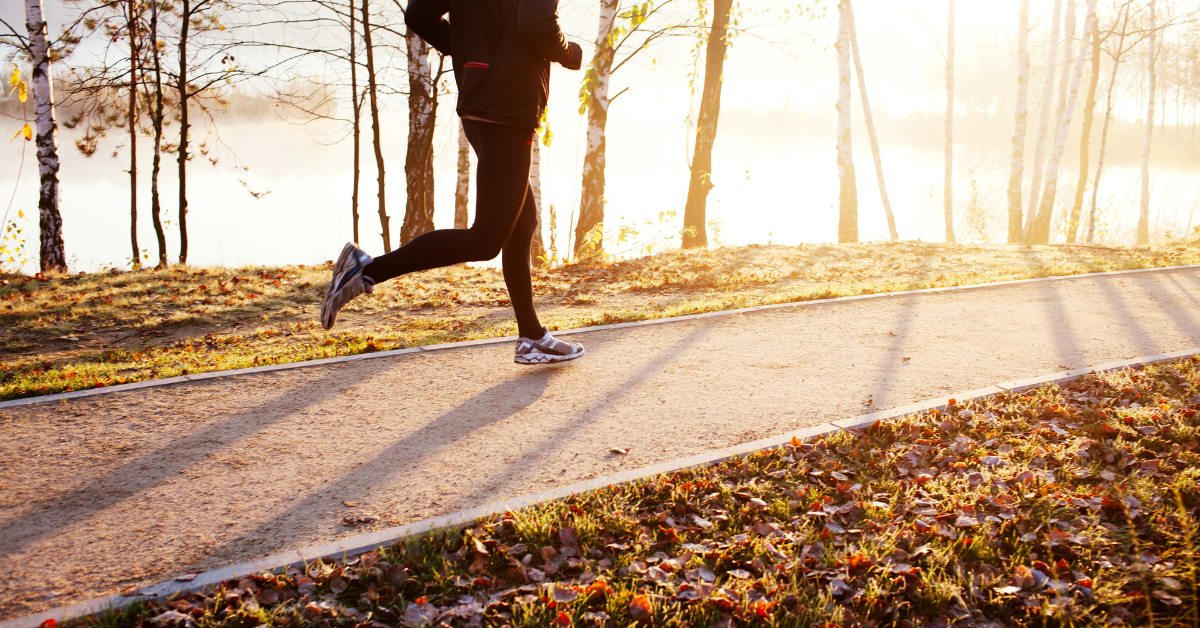 A person engaging in a healthy obsession by jogging on a path near a lake.