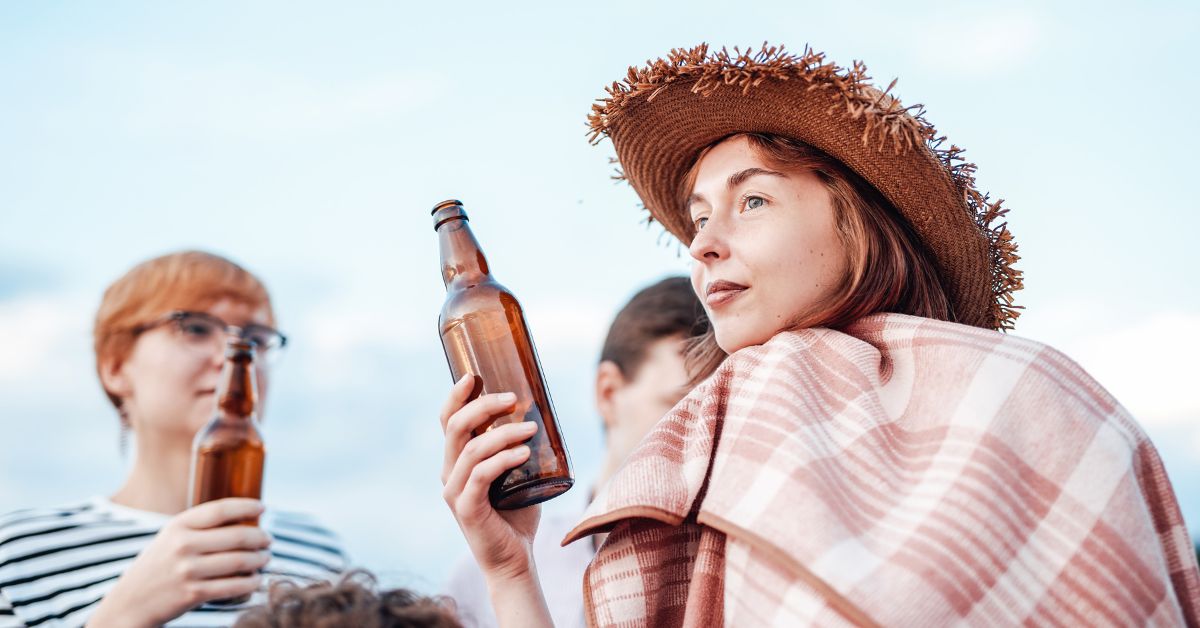 A group of teenagers engaged in binge drinking, with beer bottles in their hands.