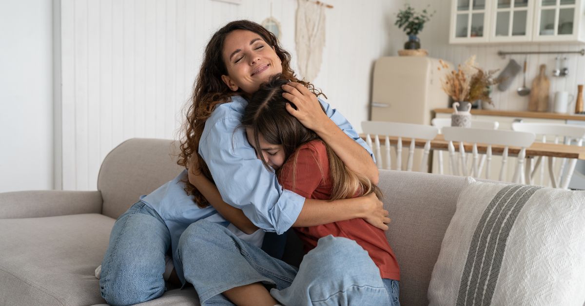 A mother huging her daughter protecting her from teenage drinking