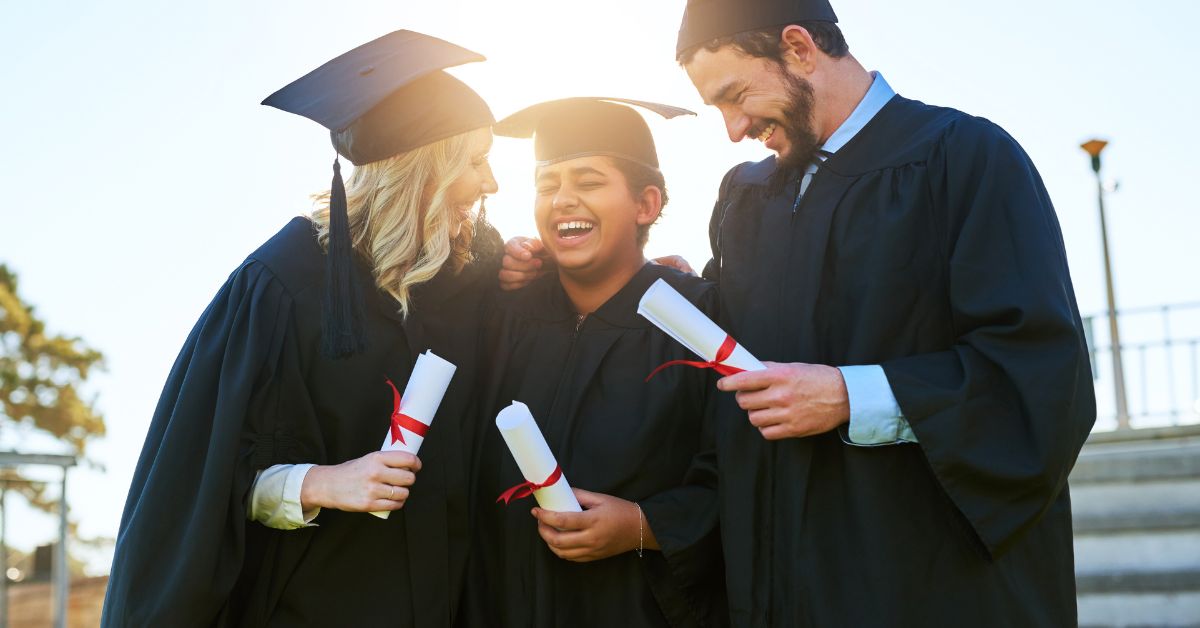 A group of people in graduation robes, opening doors to a promising future while laughing.