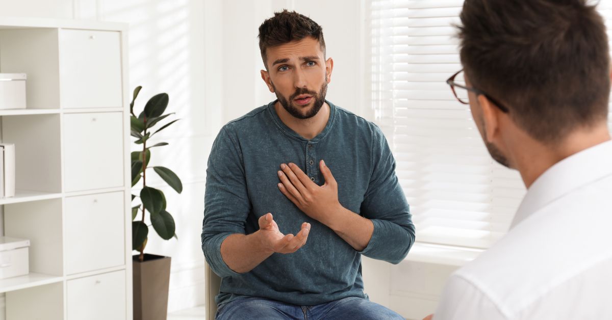 A man is discussing rehab treatment options with a doctor in an office.