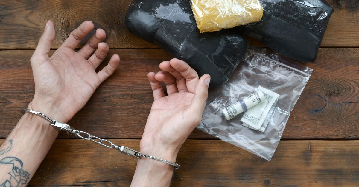 Consequences of dealing drugs displayed on a wooden table.