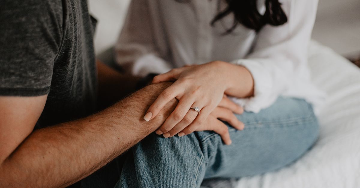 A couple affirming their commitment to sobriety while sitting on a bed.