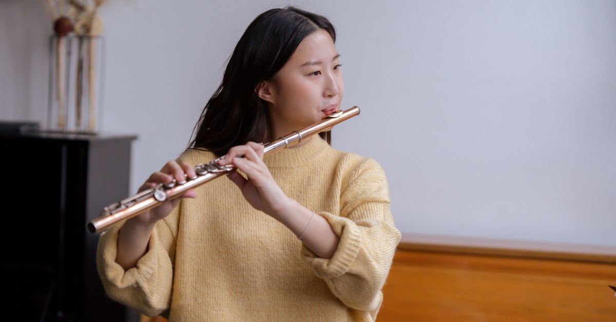 A young woman skillfully playing a flute in a peaceful living room, embracing healthy forms of self-expression and finding solace without relying on drugs.