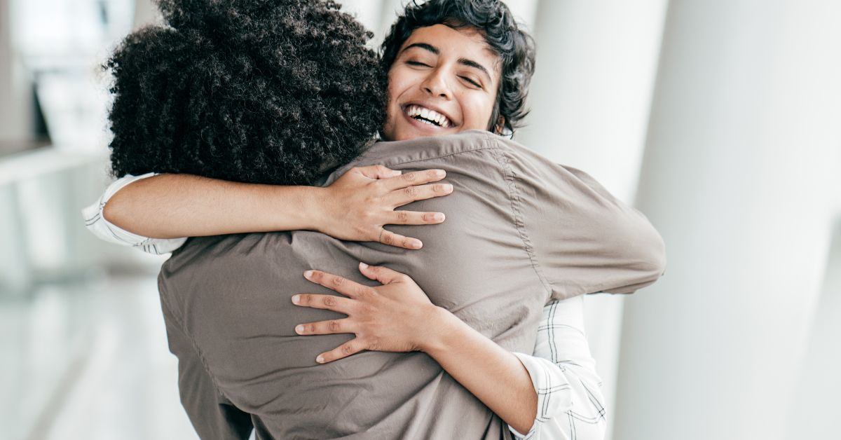 Two people embracing each other in a hallway as a symbolic gesture of the first step in recovery and maintaining sobriety.