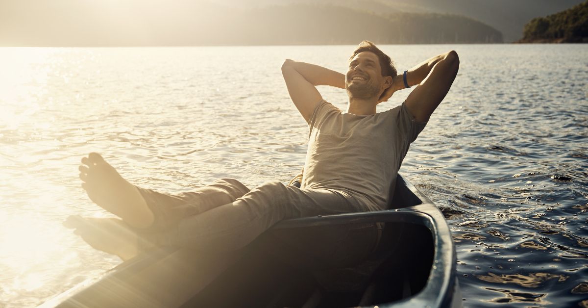 A man replacing his addiction to live a better life, relaxing in a canoe on a lake.