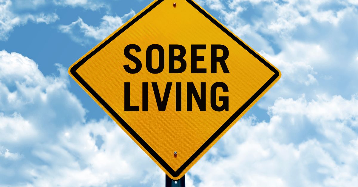 A yellow sign with the words sober living against a cloudy sky, serving as a reminder to stay committed to sobriety.