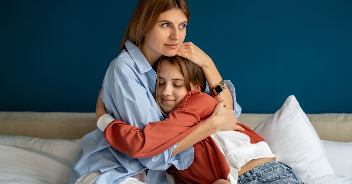 A mother and daughter overcoming teen cocaine addiction, hugging on a bed.