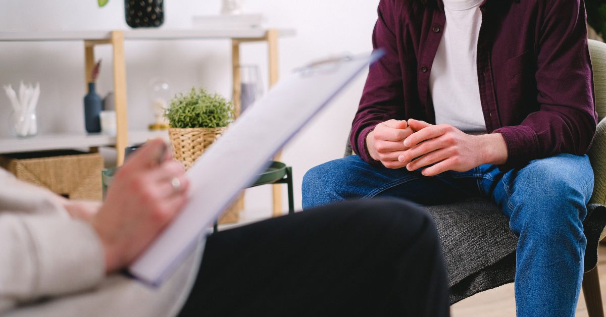 A man receiving therapy to prevent relapses while sitting in a chair.