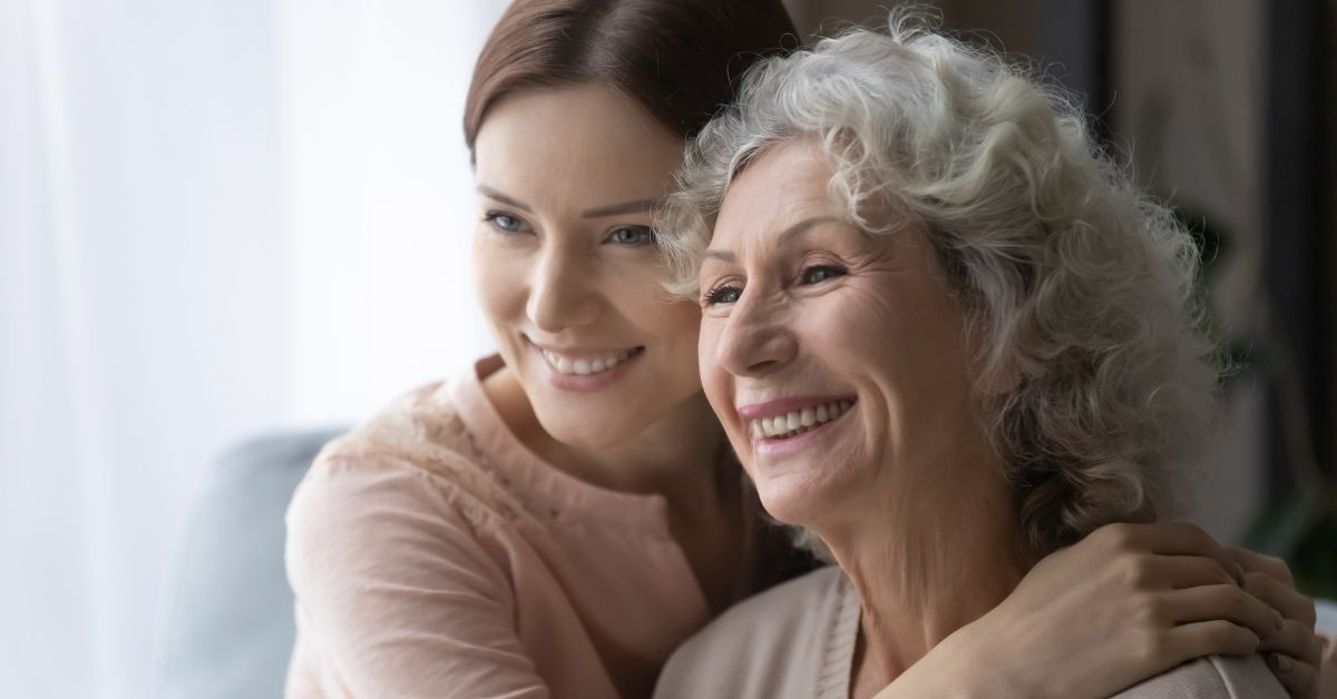 A woman is hugging an older woman in the living room, walking toward a sober living.