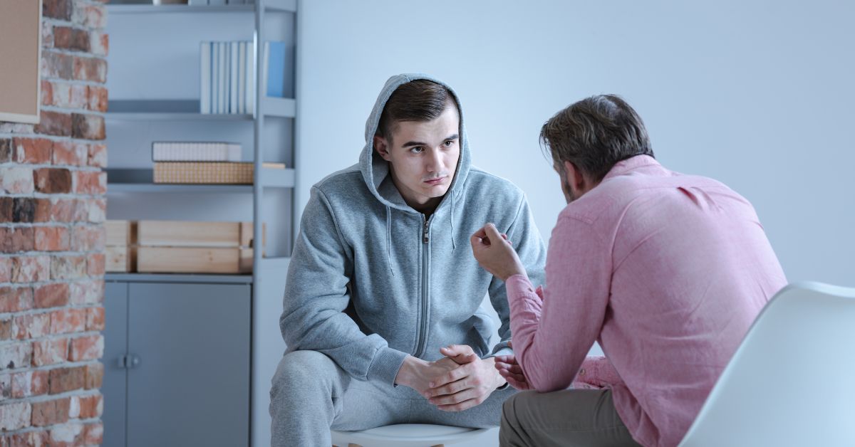 A men talking with his therapist ways to break the addiction cycle in a room.